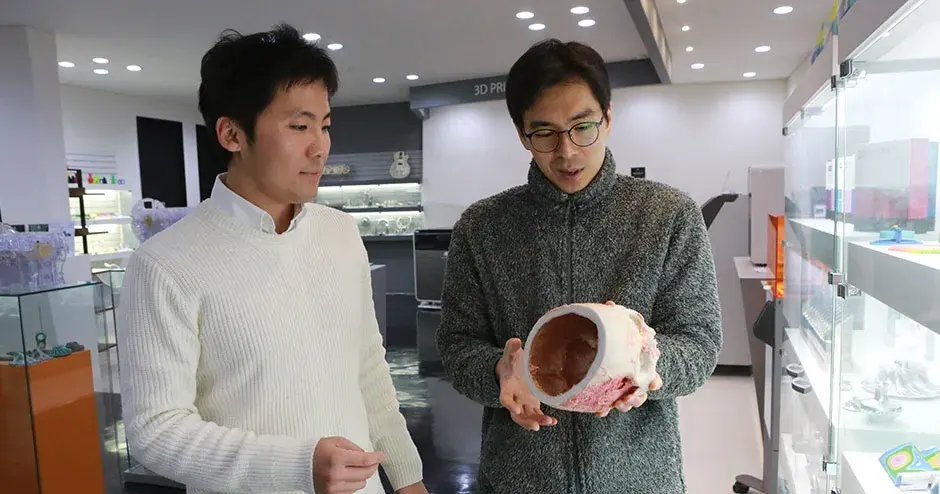 2 colegas olhando para uma impressão 3D