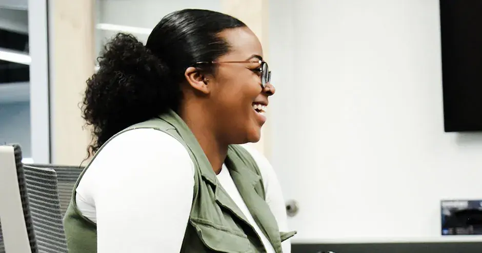 um colega sentado a uma mesa sorrindo