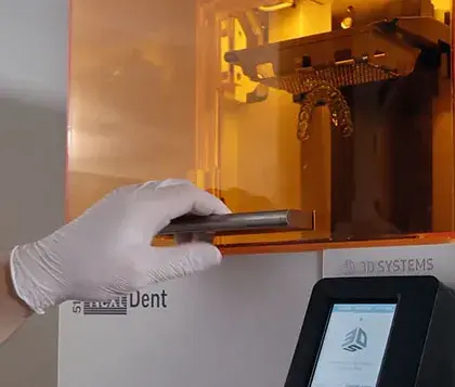 Uma pessoa usando uma impressora 3D em uma clínica dentária