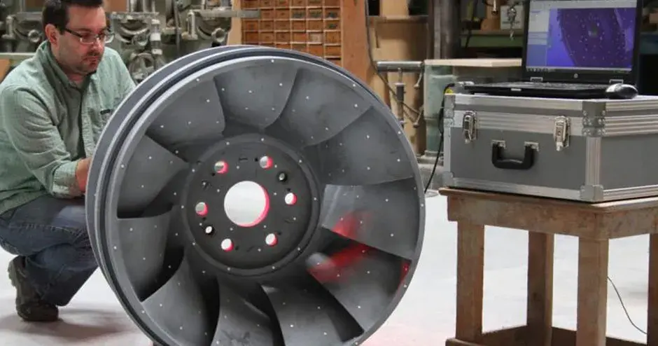 uma pessoa ao lado de uma peça de fundição de precisão em um ambiente industrial