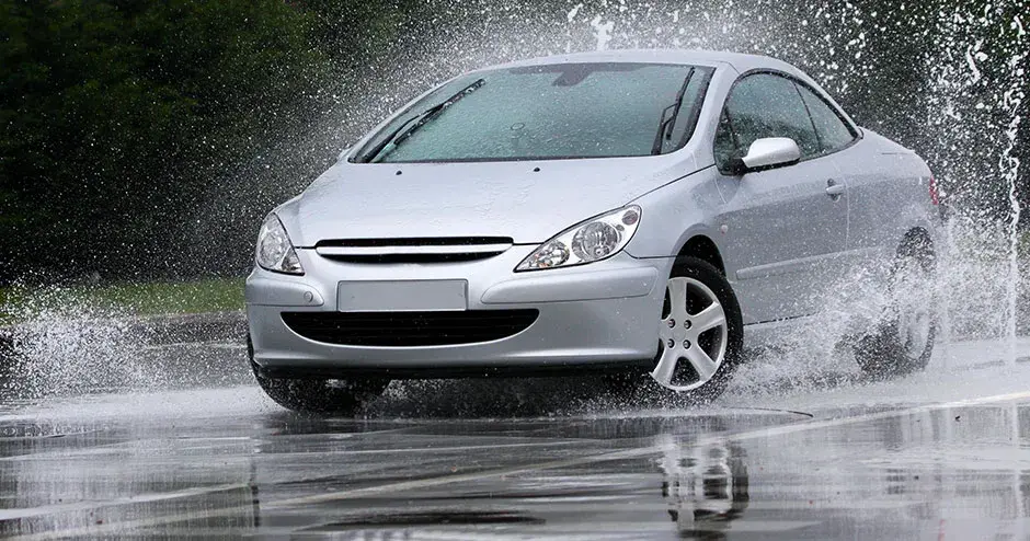 Um carro passando por uma poça e criando um gigantesco respingo