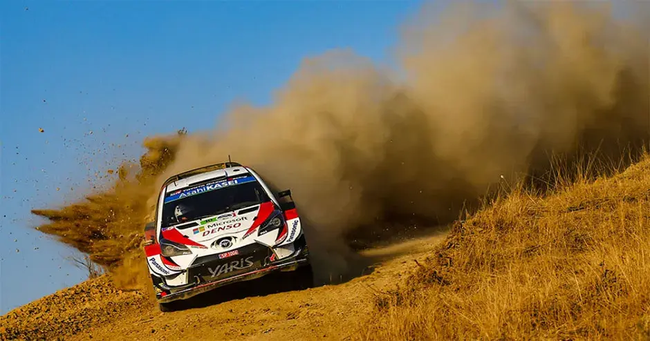 carro de corrida deixando uma enorme nuvem de poeira em seu rastro