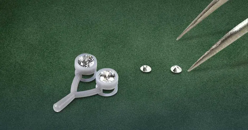 mestre de joias da figure 4 cinza pingente e colocação de pedras em um plano de fundo de veludo verde