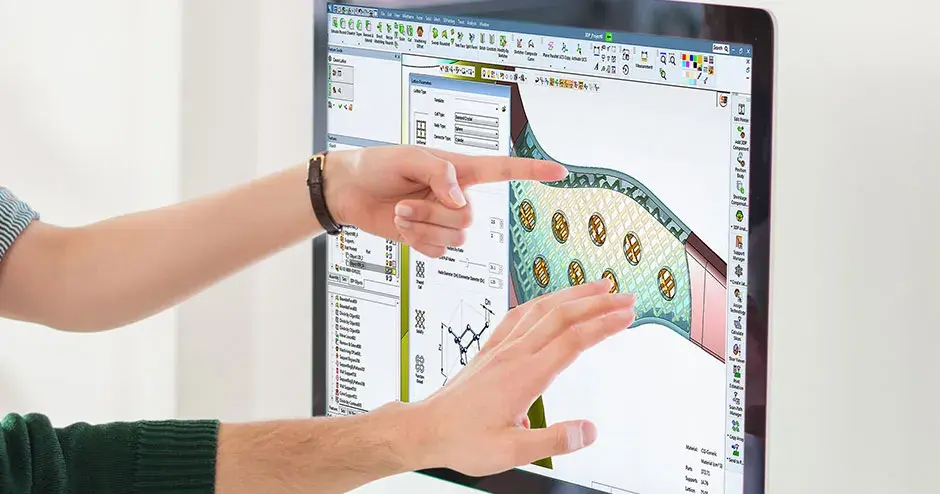 2 pessoas apontando para um monitor de computador
