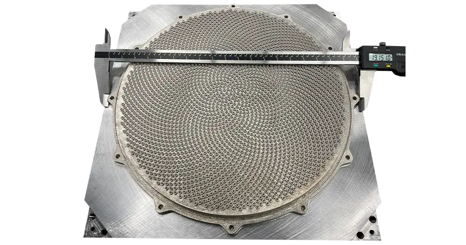 Um bico de chuveiro impresso em 3D com uma régua na parte superior mostrando as dimensões