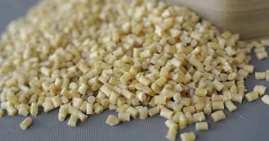 Grânulos de plástico branco acinzentado sobre um fundo cinza