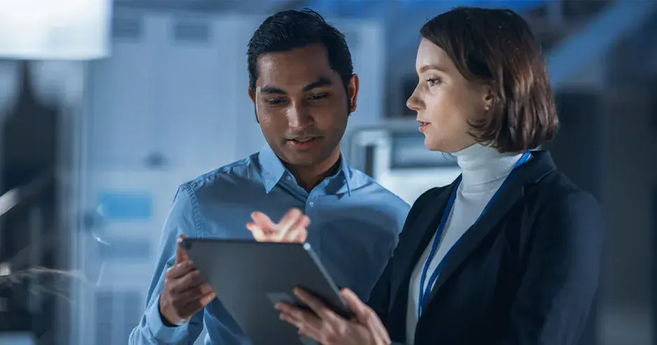 2 pessoas colaborando em um tablet em um ambiente industrial