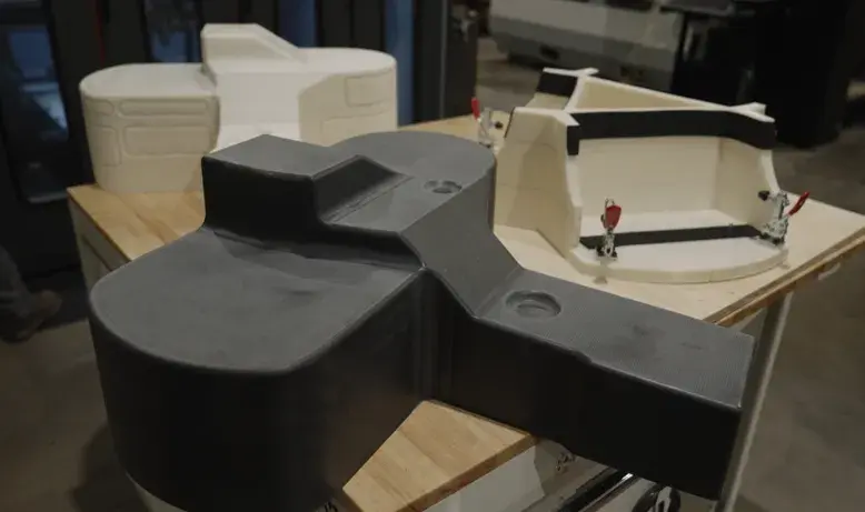 Um molde de termoformagem de CF-PC 3D impresso e usinado, um 3D impresso ABS Protótipos de uma peça formada e um 3D impresso ABS acessório de acabamento, todos produzidos no sistema de pellets EXT 1270 Titan da 3D Systems. 